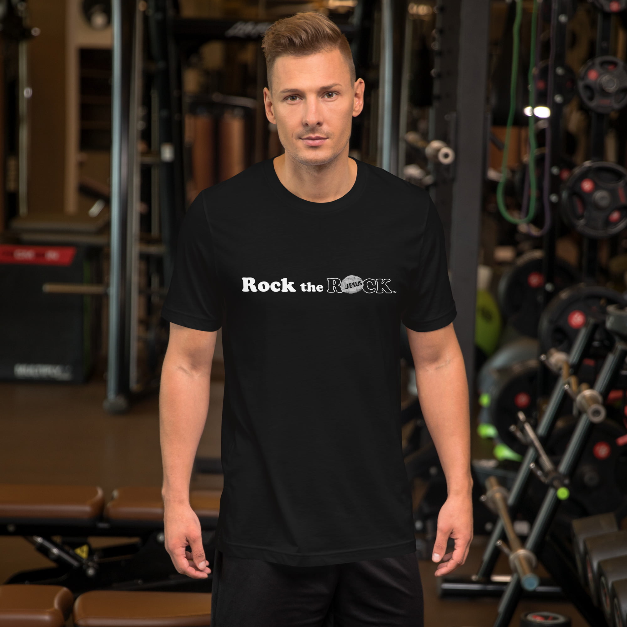 White guy in front of weight rack at gym wearing a fearless RocktheROCK t-shirt